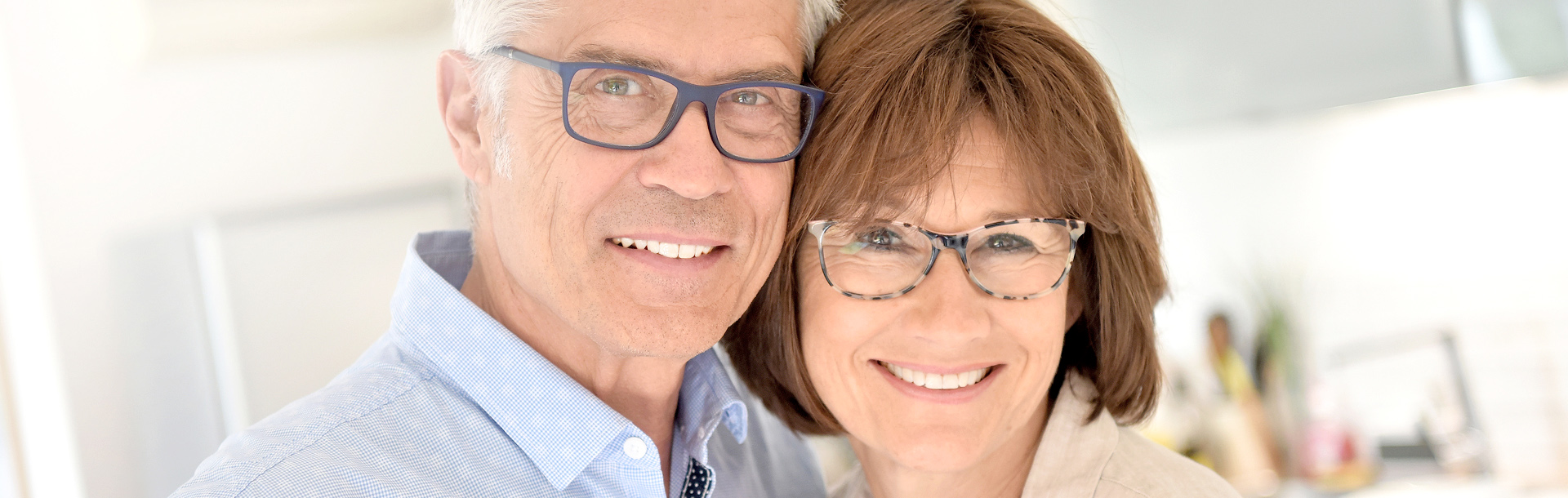 Senior couple wearing glasses cuddling close